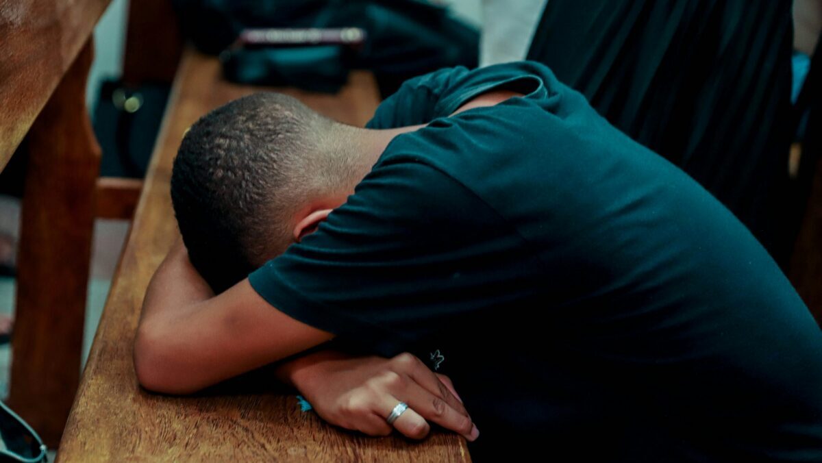 Man with his head down, feeling burnt out.